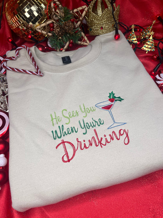 HE SEES YOU WHEN YOUR DRINKING EMBROIDERED SWEATSHIRT